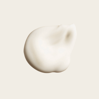 Close-up of a smooth, beige cream on a light beige background