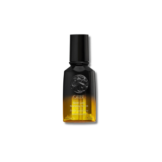 Oribe hair oil bottle with gradient label on a white background