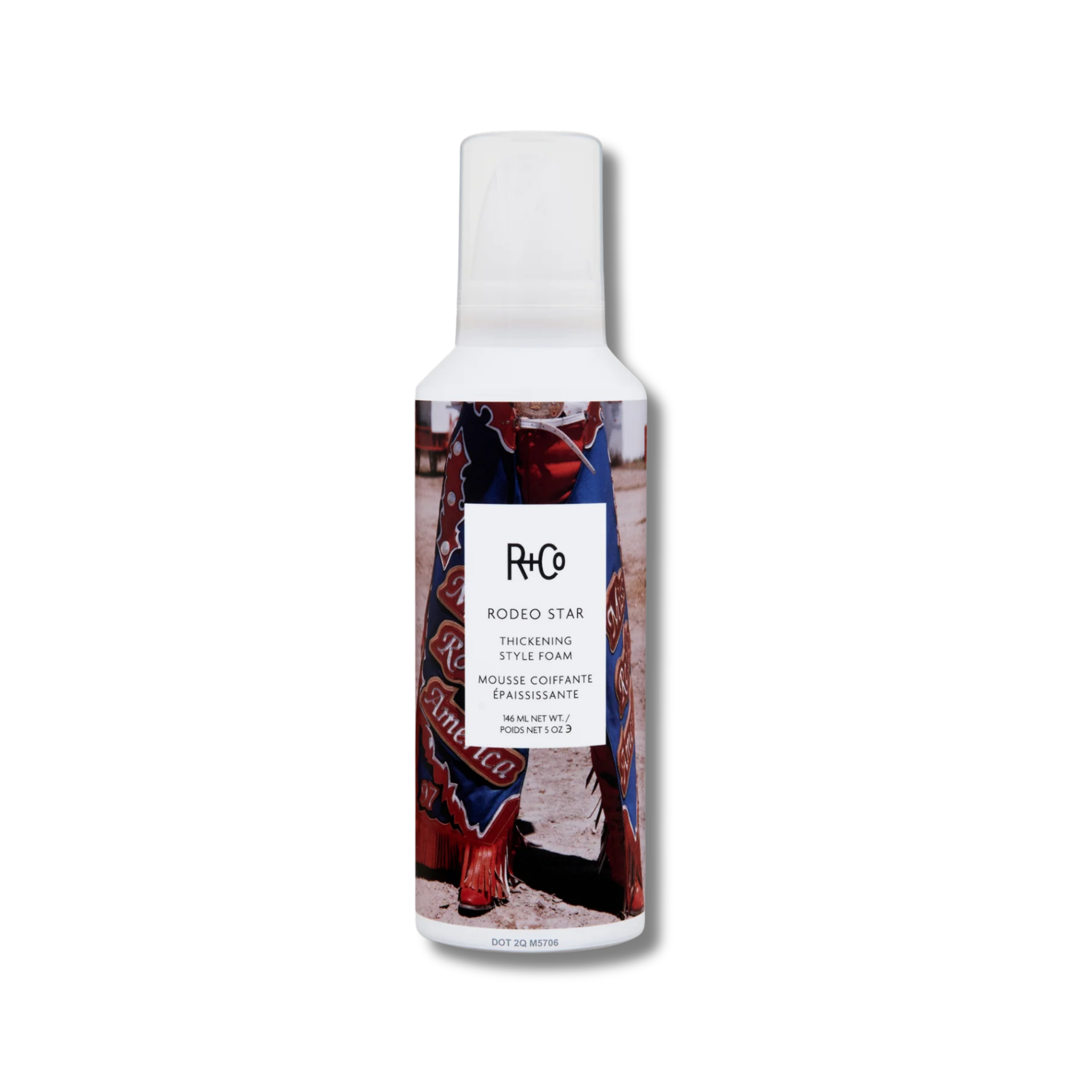 R+Co hair product bottle with a person wearing red cowboy boots on a white background