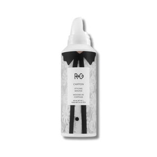Hair mousse bottle with black and white design on a white background